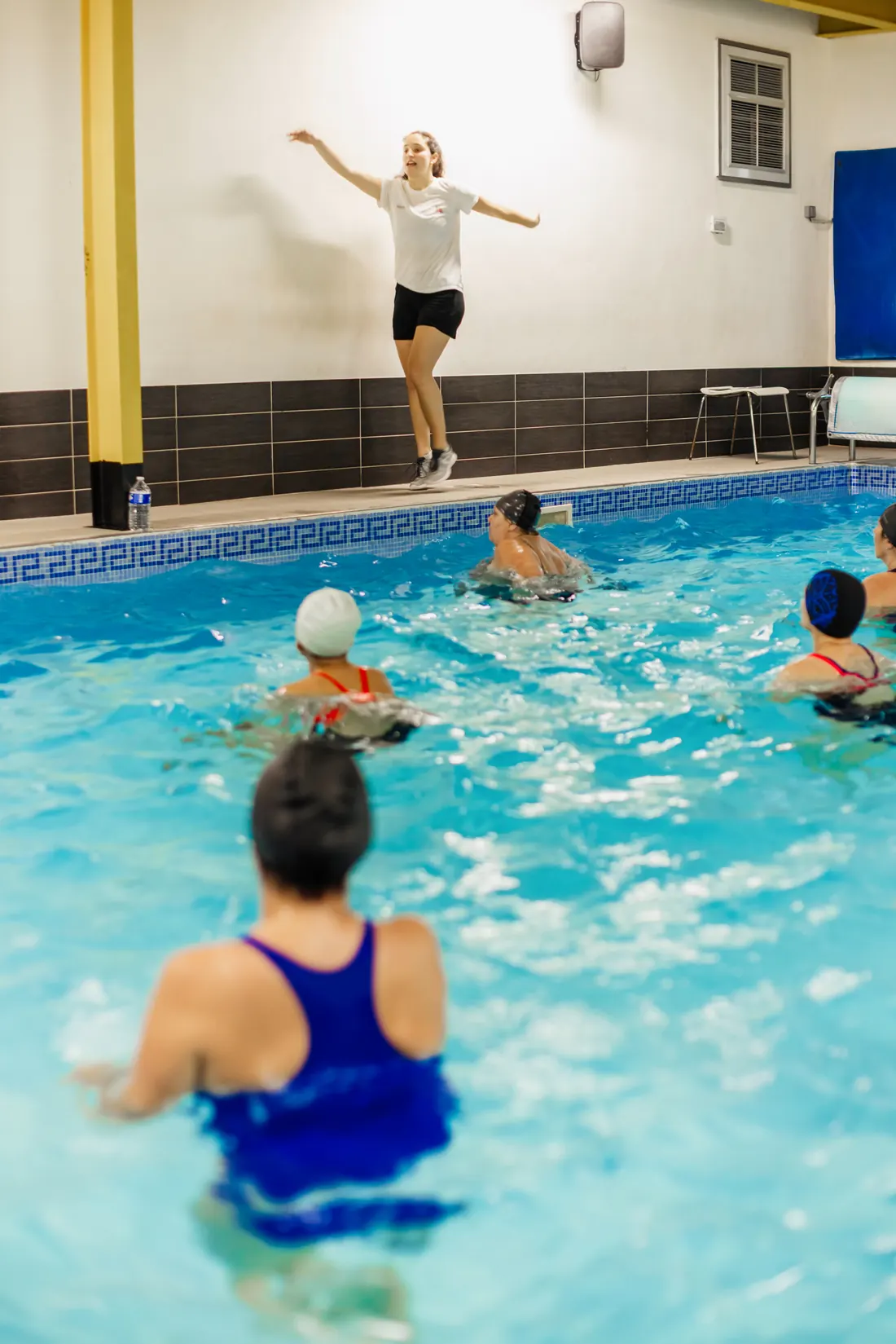 Coach animant un cours d'aquagym au bord de la piscine