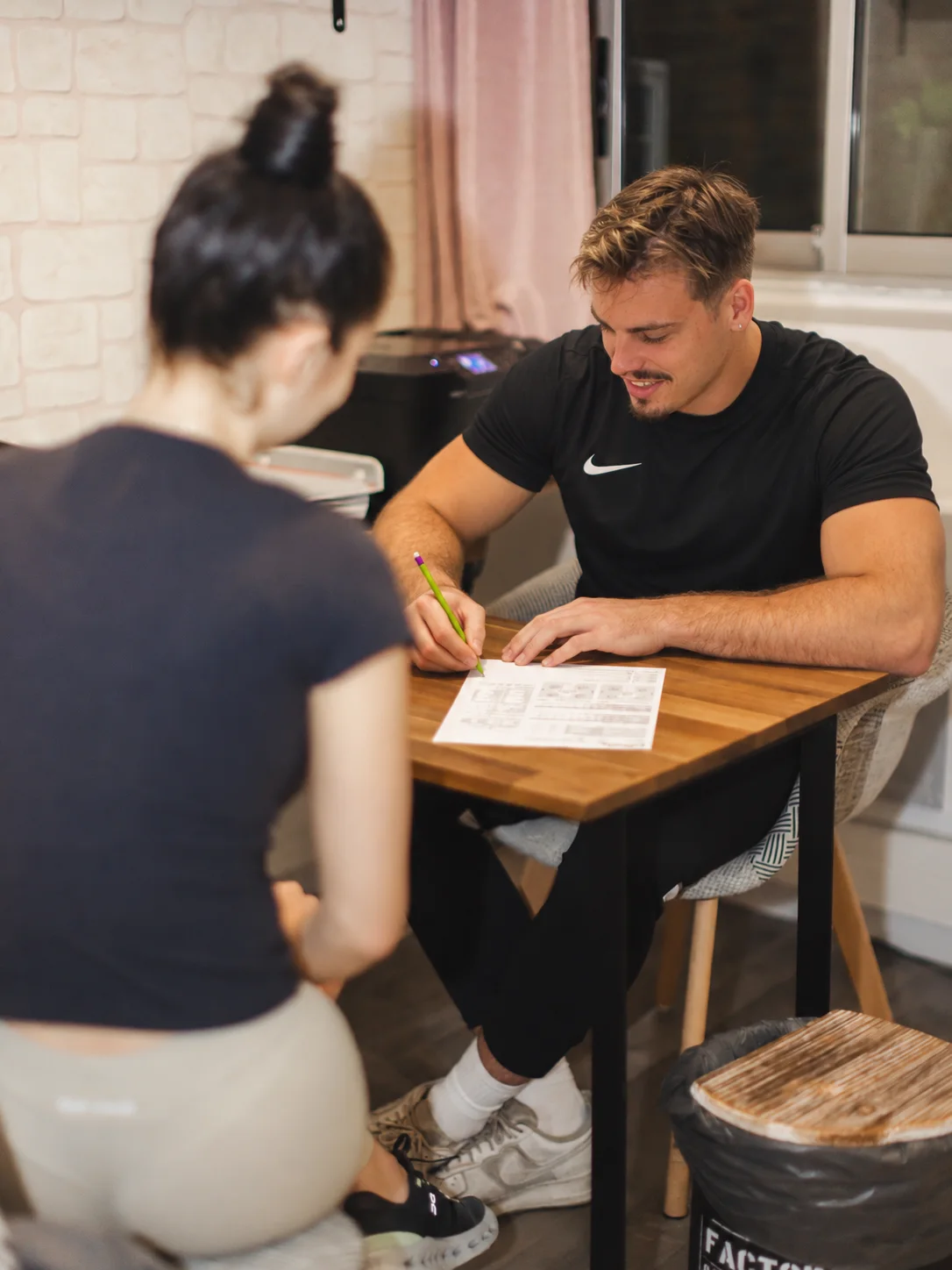 Coach du club rédigeant le programme personnalisé d'une adhérente