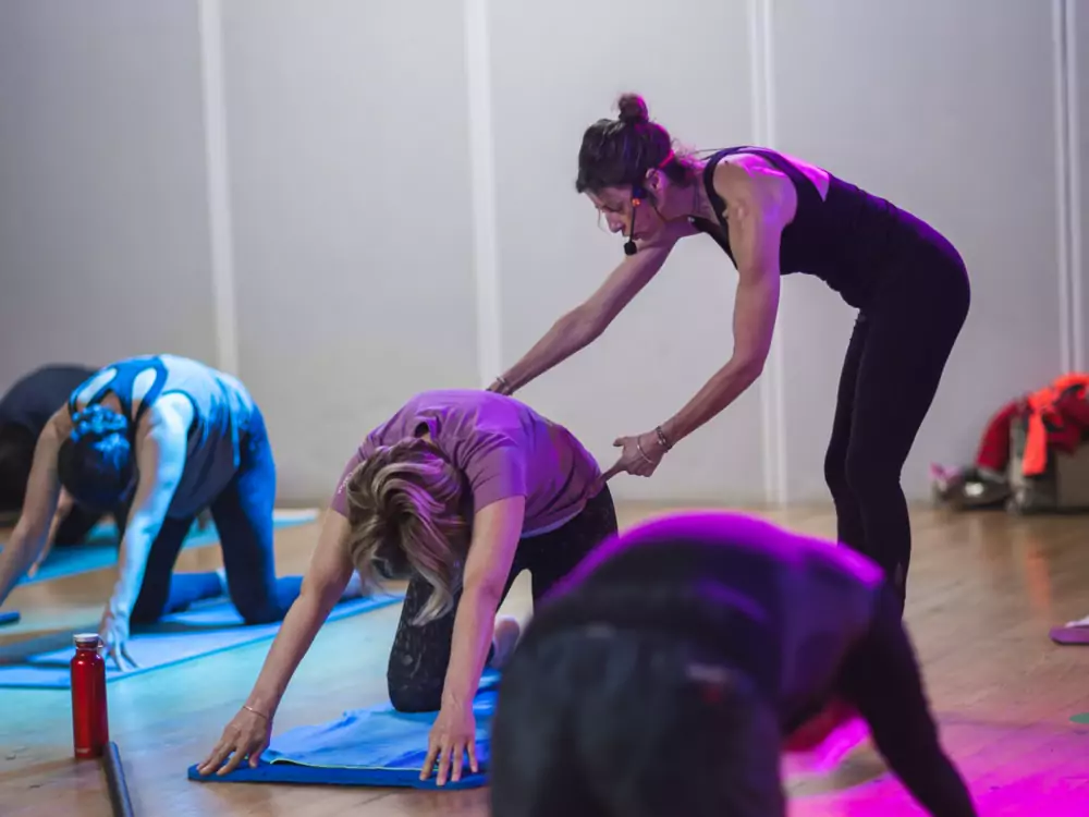 Coach corrigeant la posture du dos d'une adhérente pendant un cours au club SPORIUM FIT